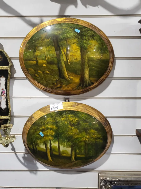 A Pair of Reproduction Oval panels of convex form, painted with woodland scenes within a gilded integral frame.