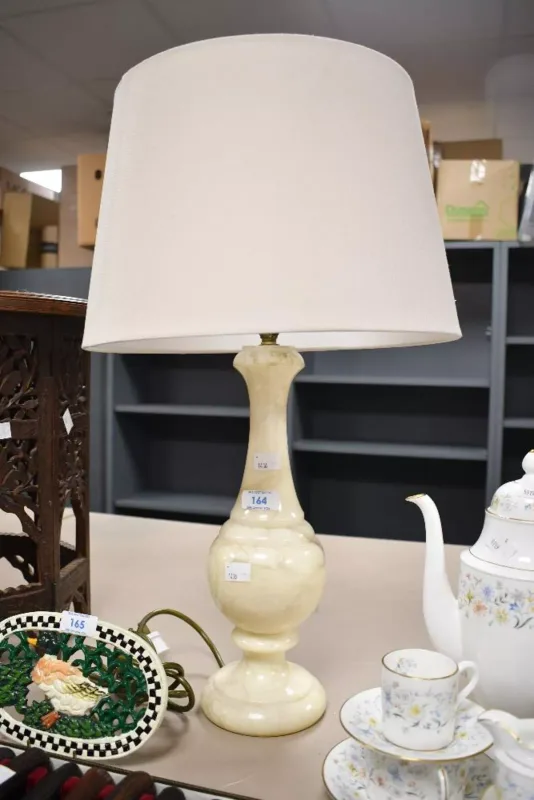 A vintage hard stone alabaster type table lamp, of soft baluster form with a cream shade, unmarked,