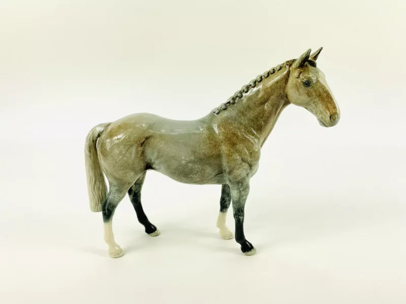 A boxed John Beswick porcelain model of a Hunter horse in a Grey/Roan gloss, model No.H260, fully marked to the underside.22.5cms wide x 7cms deep x 19cms high