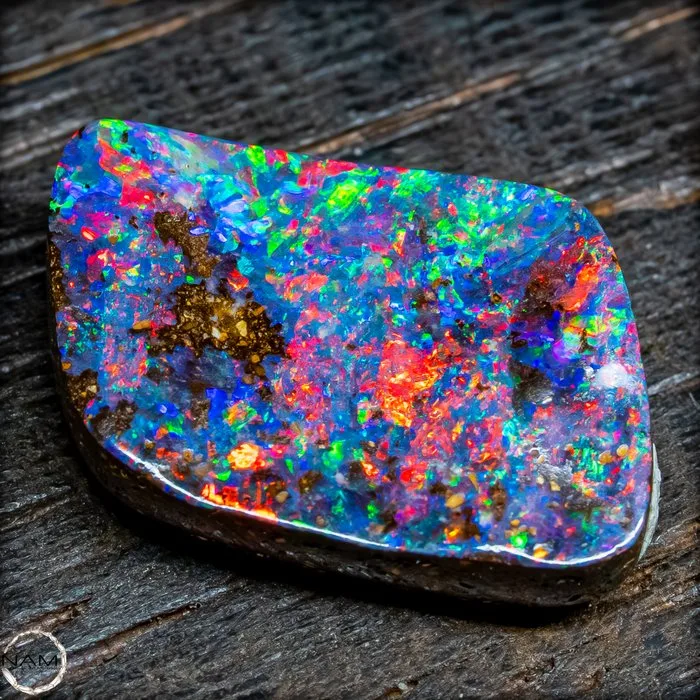 Australian Boulder Opal cabochon with an intense multicolored play of color. 7.7 ct- 1.54 g