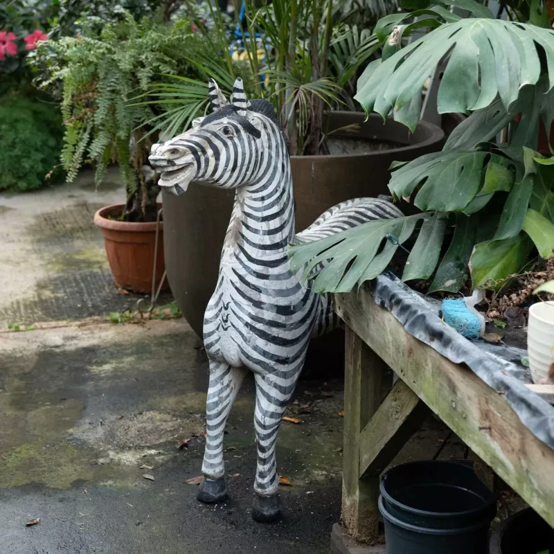 A carved wooden sculpture of a Zebra The Zebra with painted decoration to the surface Approximately