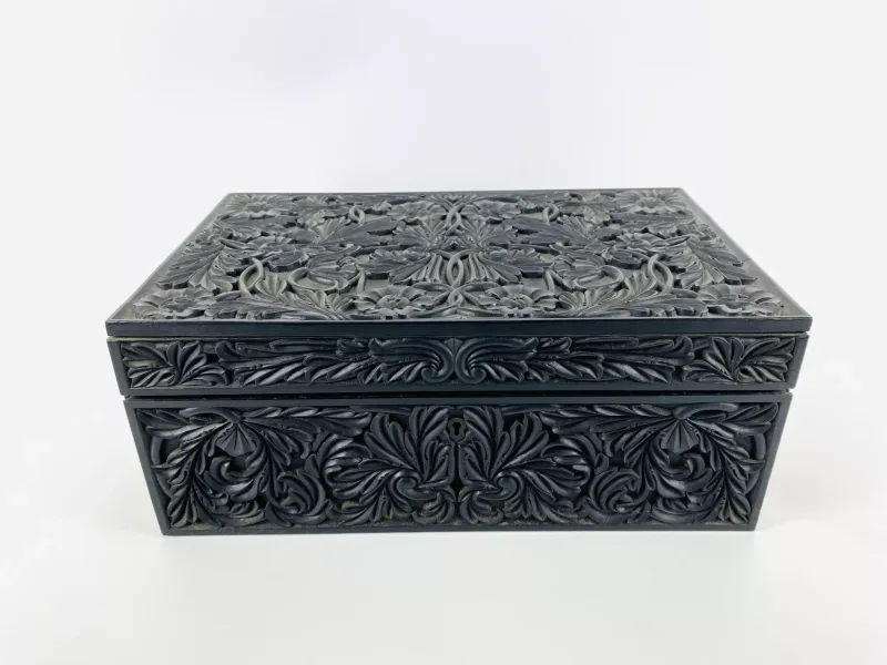 A good large 19th century Ceylonese/Anglo Indian black hardwood work box with profusely carved decoration to the exterior