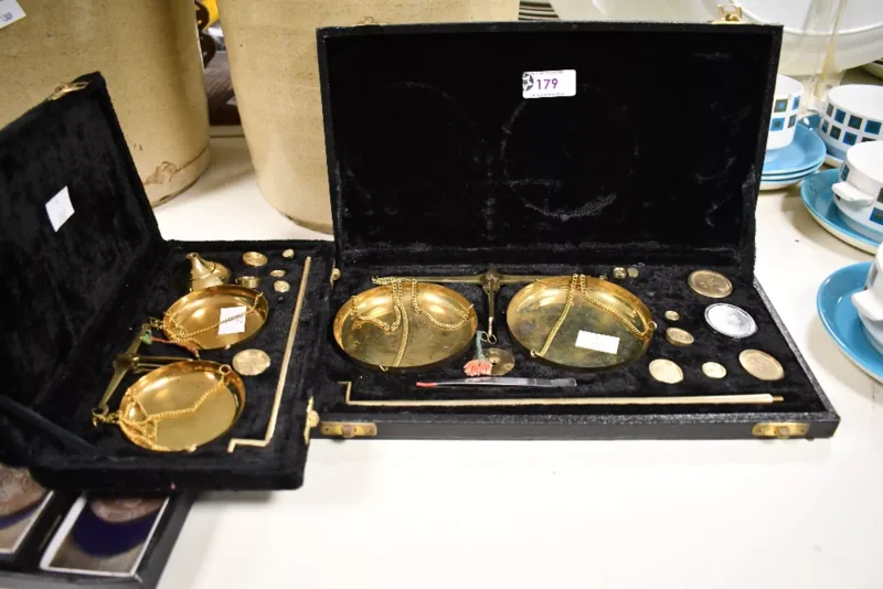 Two fine mid 20th-century portable brass pocket balance scale sets, featuring a selection of small circular graduated brass weights, tweezers