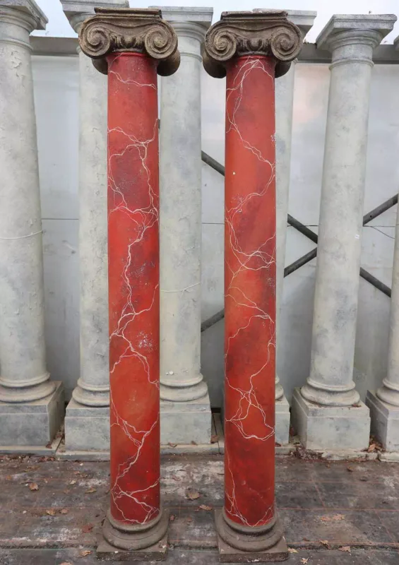 A pair of ionic columns The composite columns with ionic capitals and red painted marble effect shafts