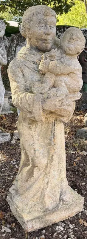 A garden sculpture depicting St Francis The cast reconstituted stone sculpture depicting a monk holding a small child