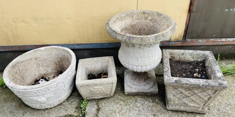 Four items to include a weathered stone garden urn (41.5cms top diameter x 51cms high), together with a circular planter, and two square section planters
