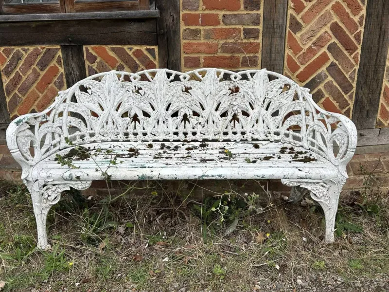 A Coalbrookdale style garden bench The white painted cast aluminium bench with lily of the valley design back