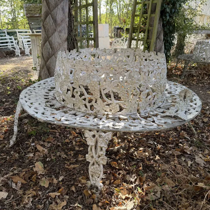 A pair of cast aluminium tree benches The circular painted benches decorated with fruiting vine ornament and pierced scroll decoration to the seat