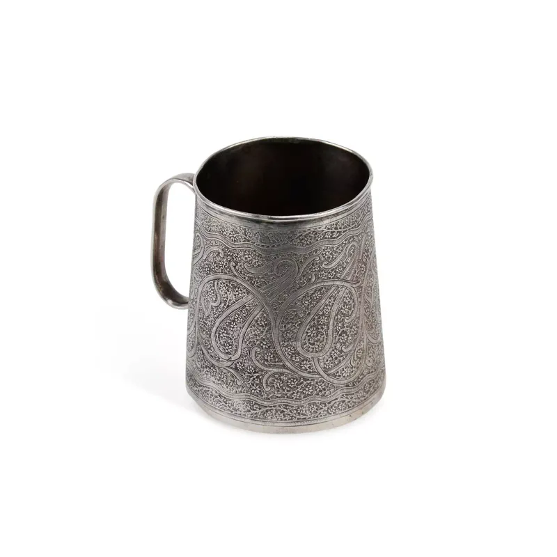 An Indian Silver Mug late 19th Century, unmarked, of tapering cylindrical form, with engraved scrolling tendrils on a foliate ground.