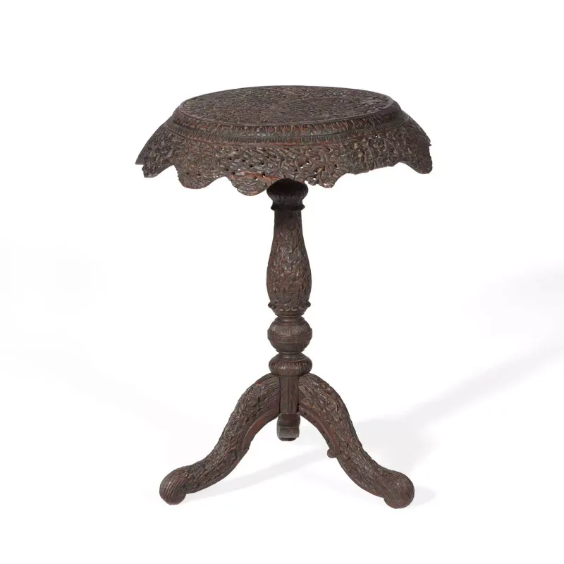 An Indian Carved Hardwood Occasional Table 19th Century, the circular top with a pierced foliate carved border