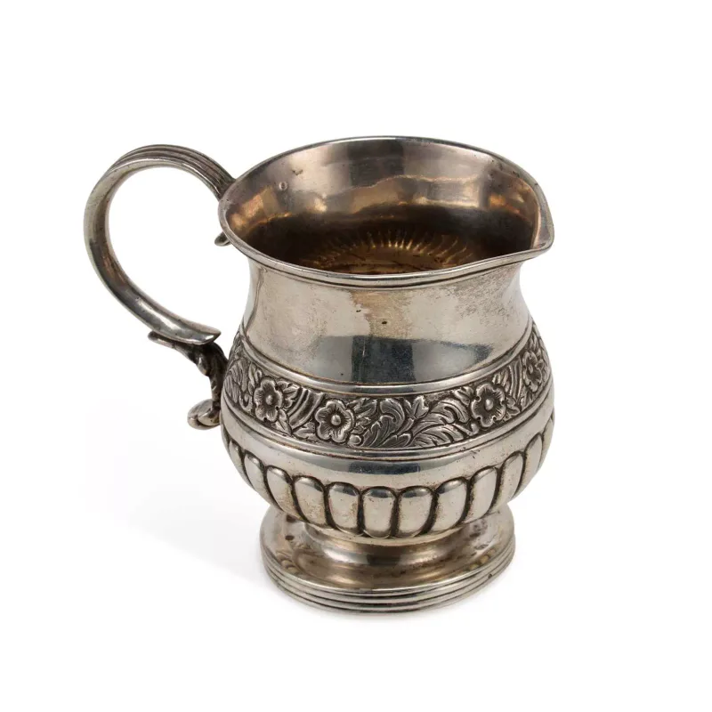 A Colonial Indian Silver Cream Jug early 19th Century, possibly by Hamilton Co., Calcutta, of circular form, demi-fluted with embossed floral band