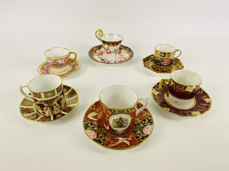 A collection of decorative porcelain cabinet coffee cans and saucers, to include Royal Crown Derby, all items fully marked to the underside
