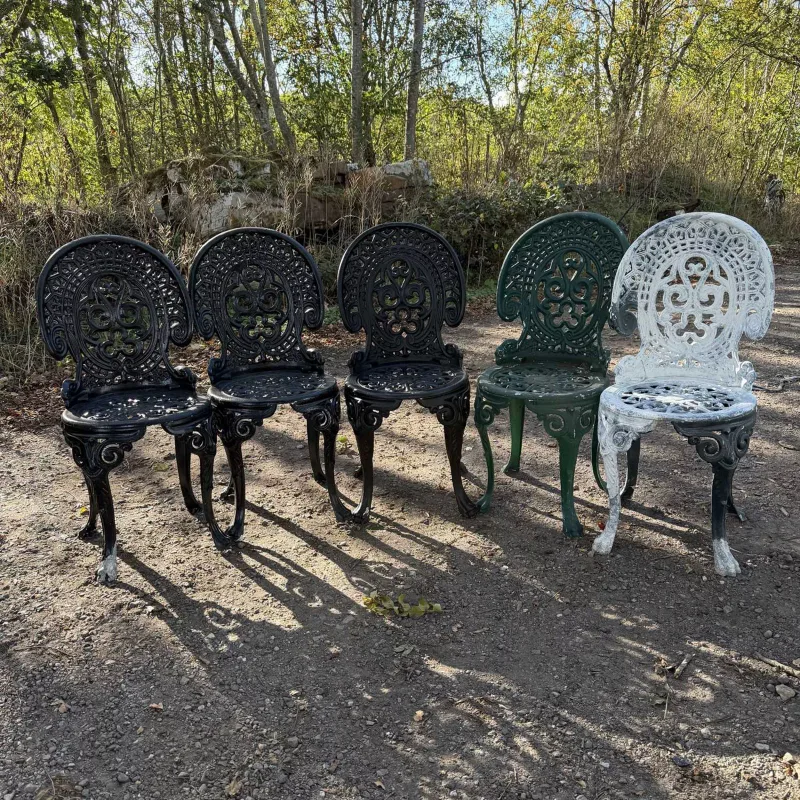 A set of five garden chairs The painted cast aluminium chairs with pierced scroll decorated backs and tracery style pierced seats