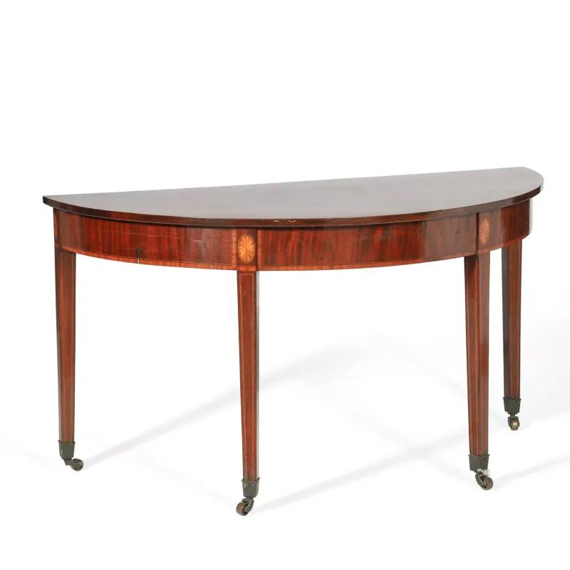 A George III Inlaid Mahogany Console Table of demilune form, upon square tapering legs with brass castors.