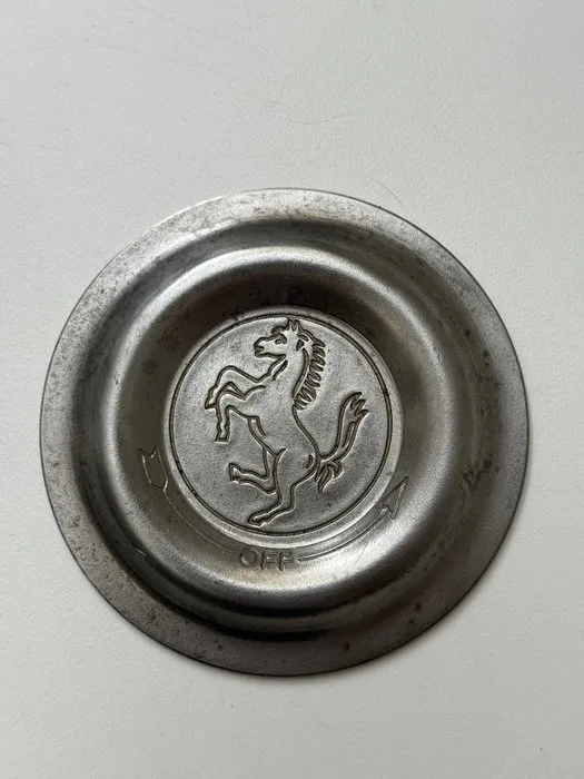 Badge - Ferrari - La placca di copertura con il logo del cavallino rampante intarsiata al centro del dado di fissaggio - 1960