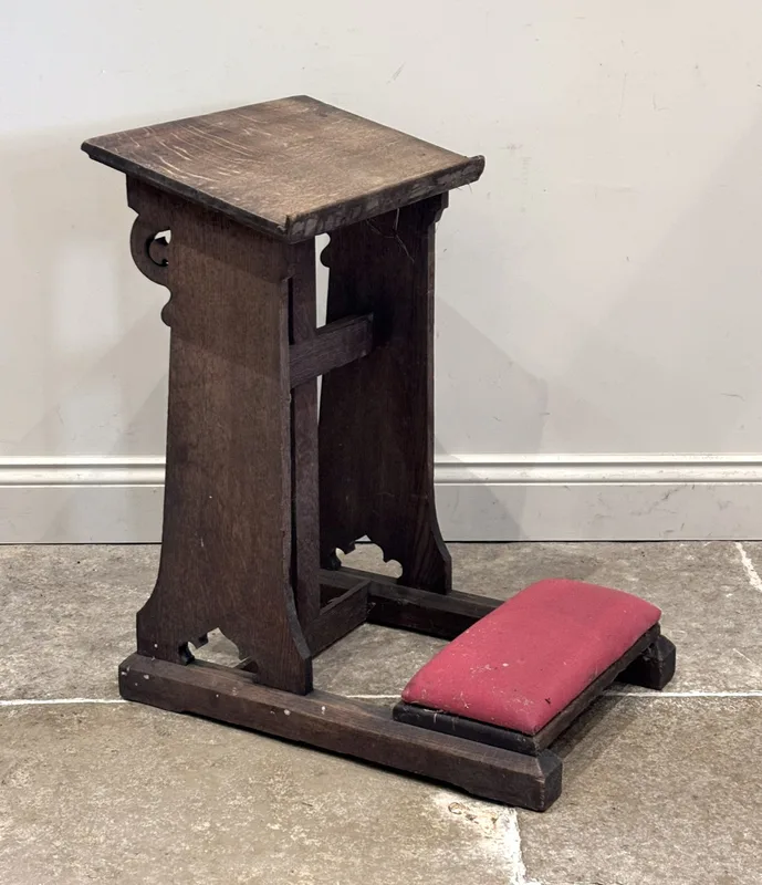 An Ecclesiastical oak prayer kneeler, with reading platform and upholstered base,
