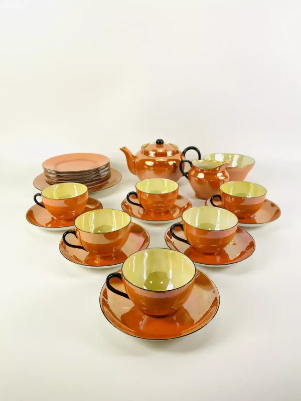 A stylish 1930's/1940's porcelain orange lustre glaze tea service comprising of a cake plate, six cups, six saucers, teapot, sugar bowl, and jug
