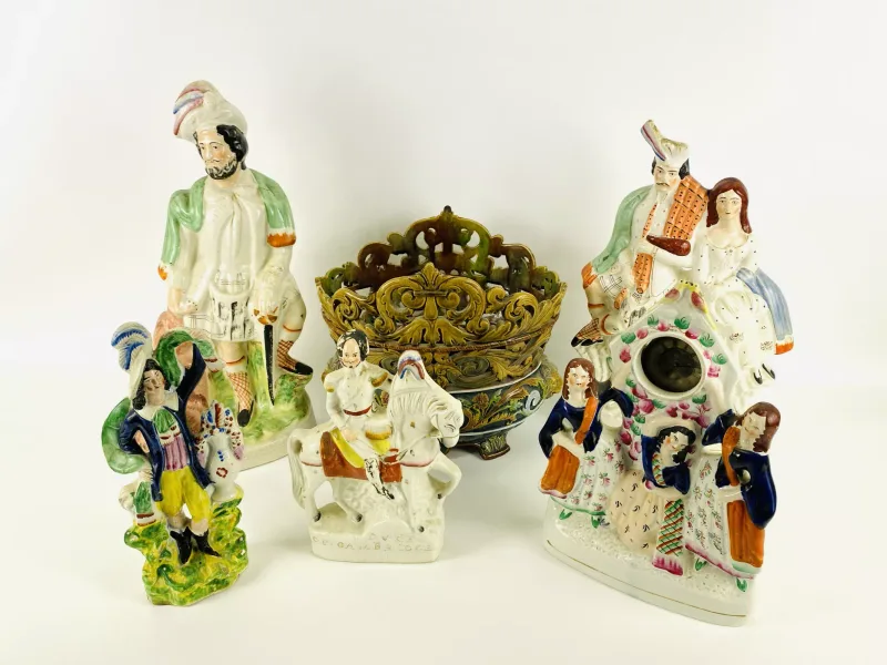 A collection of five 19th century Staffordshire pottery figurines to include a pocket watch holder with a silver cased pocket watch
