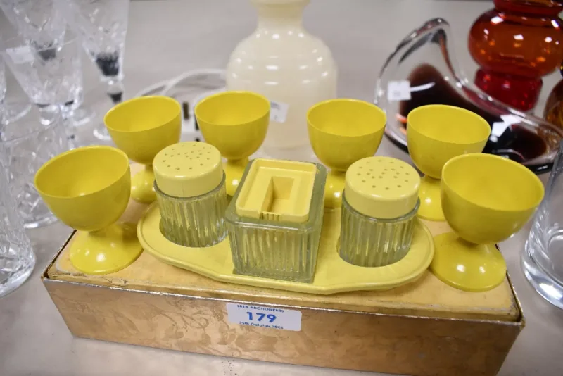 An early 20th-century yellow bakelite breakfast set, to feature six egg cups and a small cruet set, unmarked, (7),