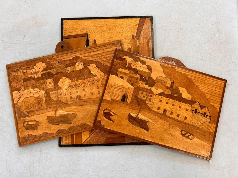 Three 20th century marquetry inlaid panels, two depicting a fishing harbour, approx.