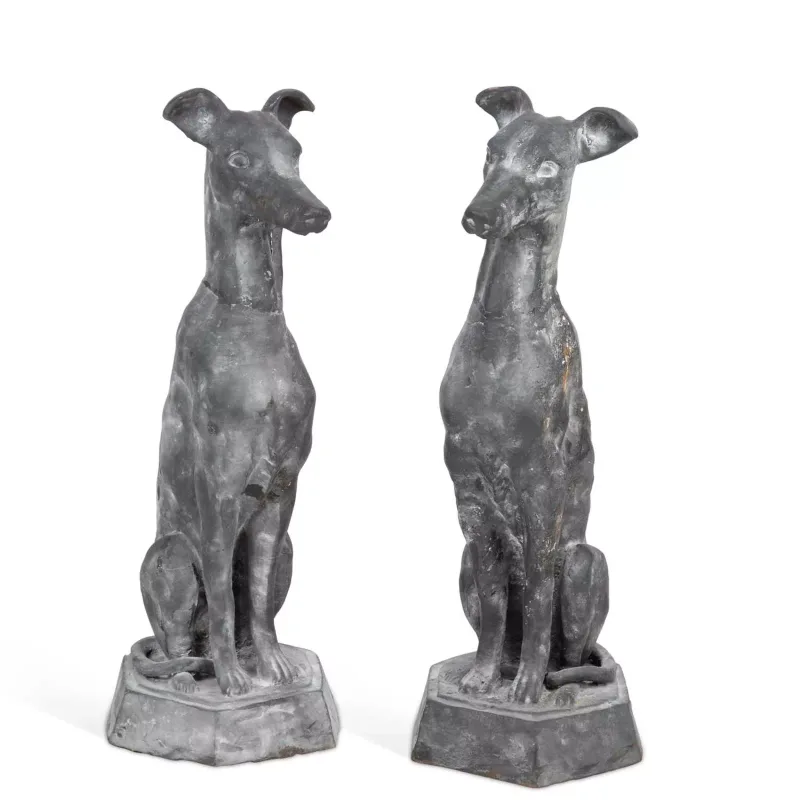 A Pair Of Cast Metal Models Of Seated Whippets each modelled seated, raised upon a shaped octagonal plinth