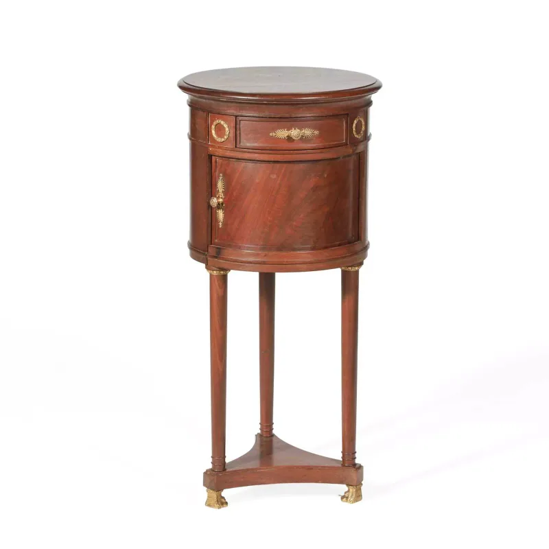 A Mahogany Cylindrical Side Table with gilt metal mounts, the cylindrical body with a frieze drawer above a cupboard door